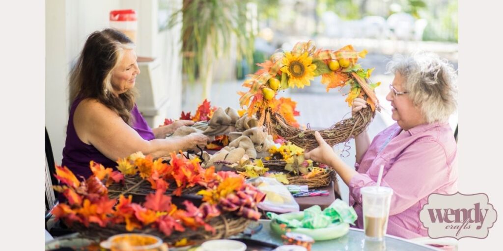 Two women with wreath-making supplies.