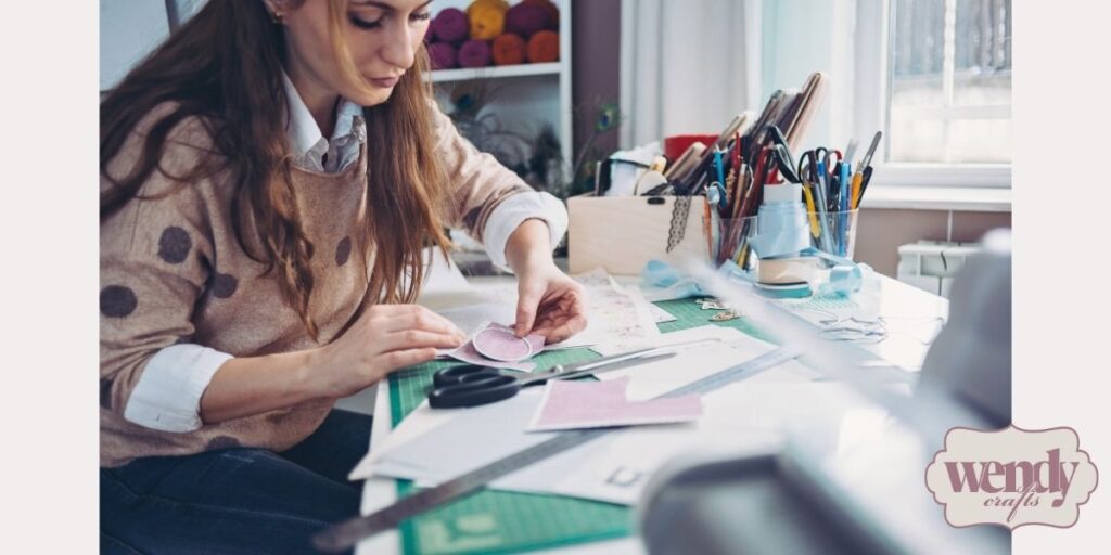 A woman working on a project using paper crafting supplies.